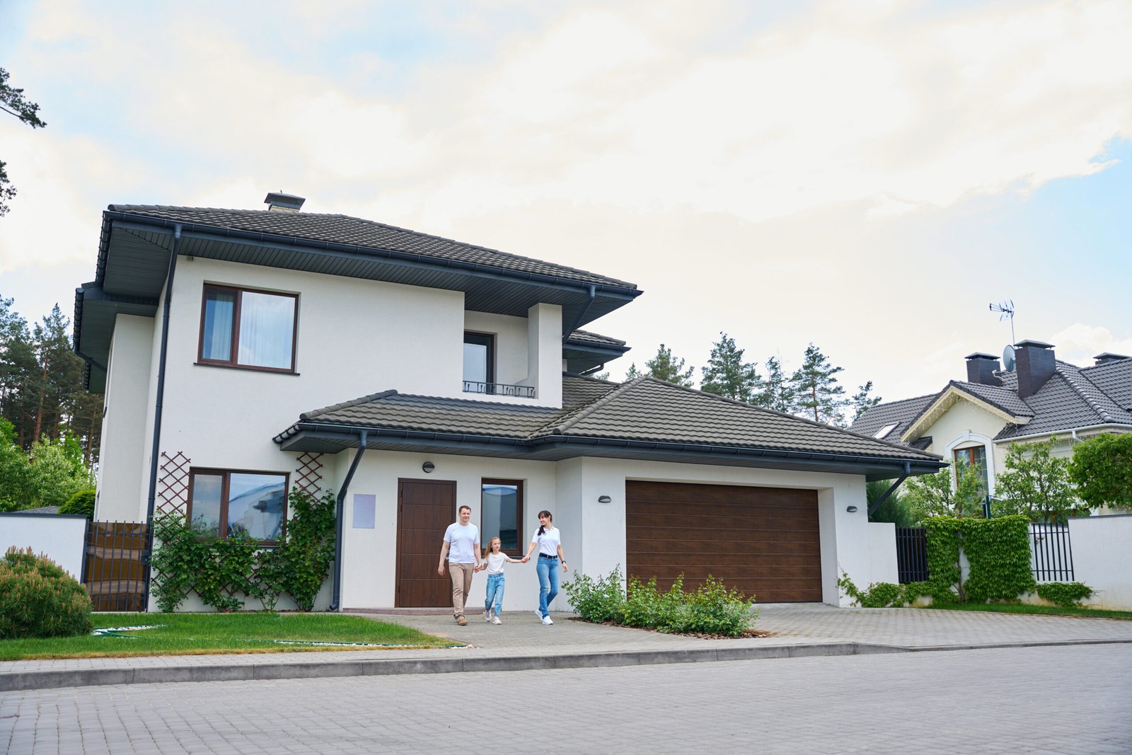 Famille satisfaite devant leur maison après pose de menuiseries Isère Savoie